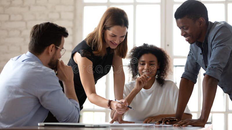 Happy diverse colleagues working on project documents together stock photos
