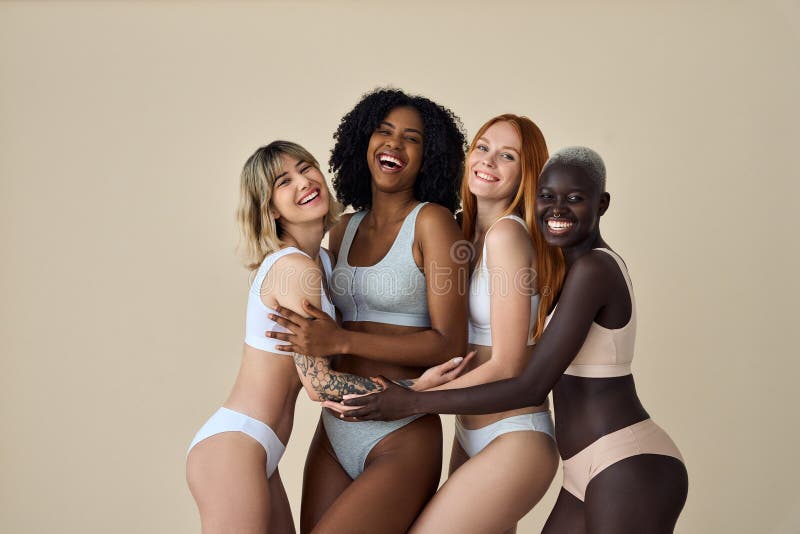 Happy Diverse Young Women Group Wearing Underwear Hugging on Beige