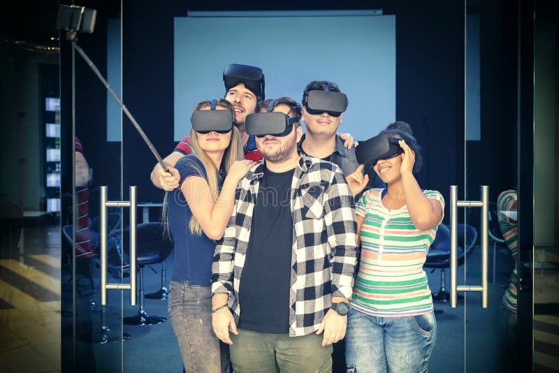 Happy multiracial friends group taking selfie playing vr glasses indoor stock photo Happy multiracial friends group taking selfie playing vr glasses indoor stock photo