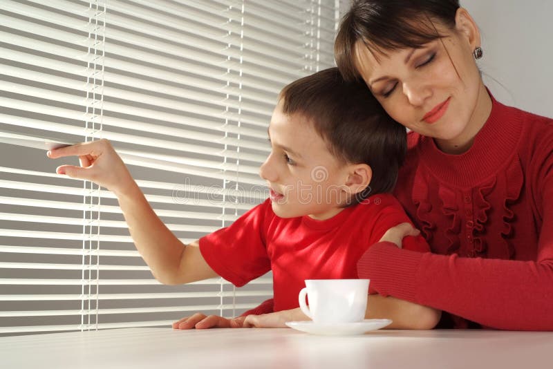 Happy mummy hugs her son sitting at a table