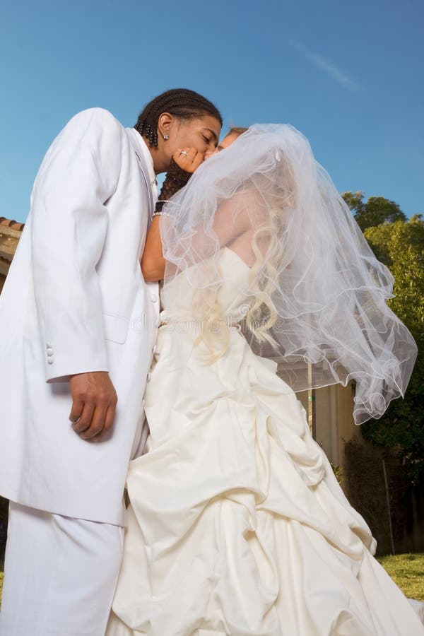 Interracial couple outdoors. Smiling laughing newlywed young Caucasian woman and mid aged ethnic black man of African American and Italian ethnicity. Interracial couple outdoors. Smiling laughing newlywed young Caucasian woman and mid aged ethnic black man of African American and Italian ethnicity