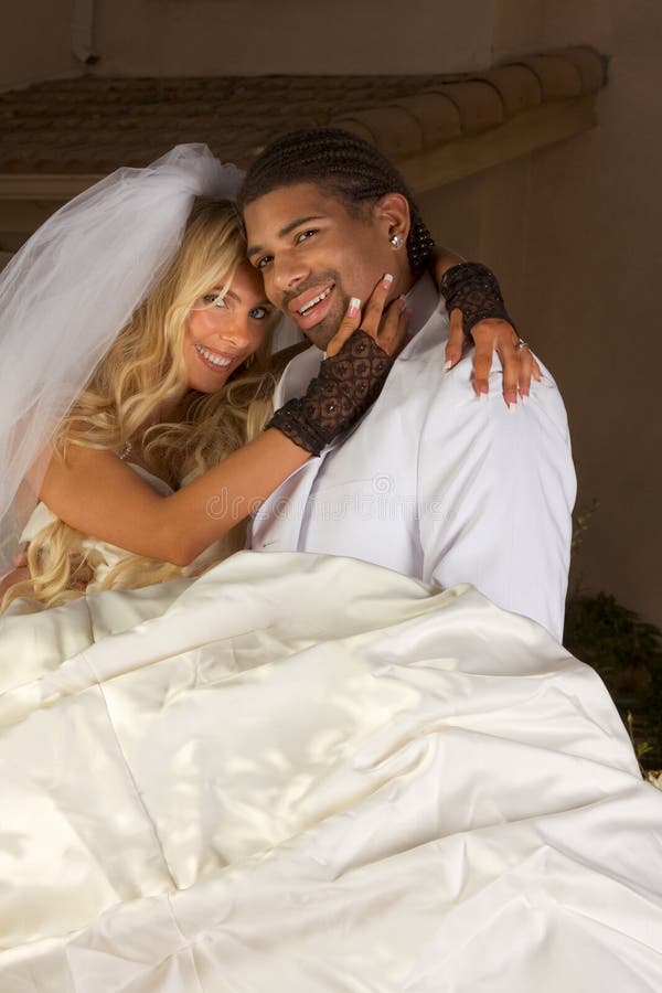 Interracial couple outdoors. Smiling laughing newlywed young Caucasian woman and mid aged ethnic black man of African American and Italian ethnicity. Interracial couple outdoors. Smiling laughing newlywed young Caucasian woman and mid aged ethnic black man of African American and Italian ethnicity