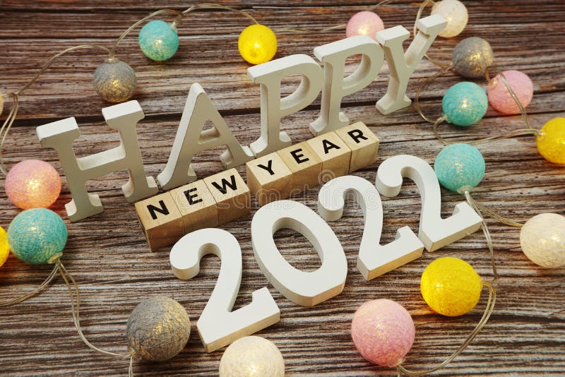 Happy New year 2022 alphabet letter with LED cotton balls decoration on wooden background. Top view of Happy New year 2022 alphabet letter with LED cotton balls stock photo