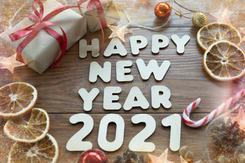 Happy new year 2021. Christmas composition. New year`s layout on a dark wooden background. Cones, toys, gift, garland