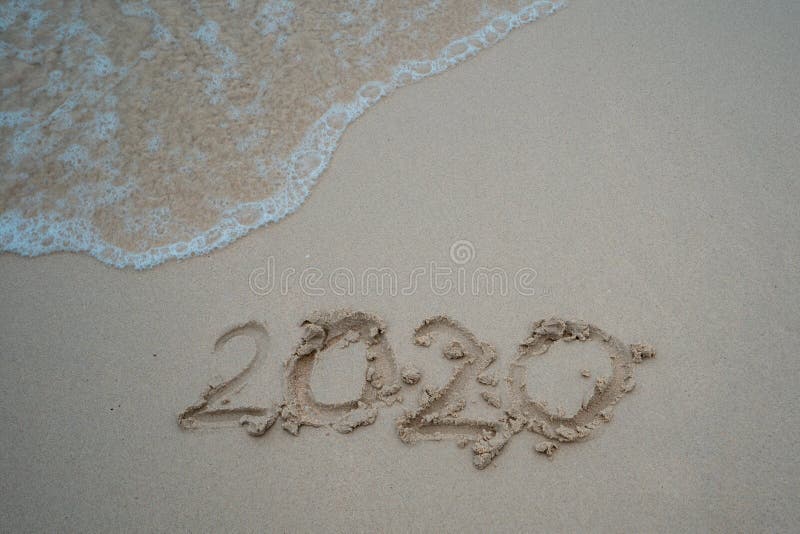 Happy New Year 2020 concept, 2020 number lettering on the sea beach, wave and golden light of sunset.  royalty free stock photo