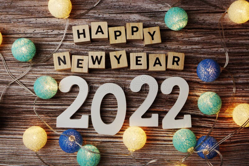 Happy New Year 2022 decorate with LED cotton ball on wooden background. Top view of Happy New Year 2022 decorate with LED cotton ball on wooden background stock photo