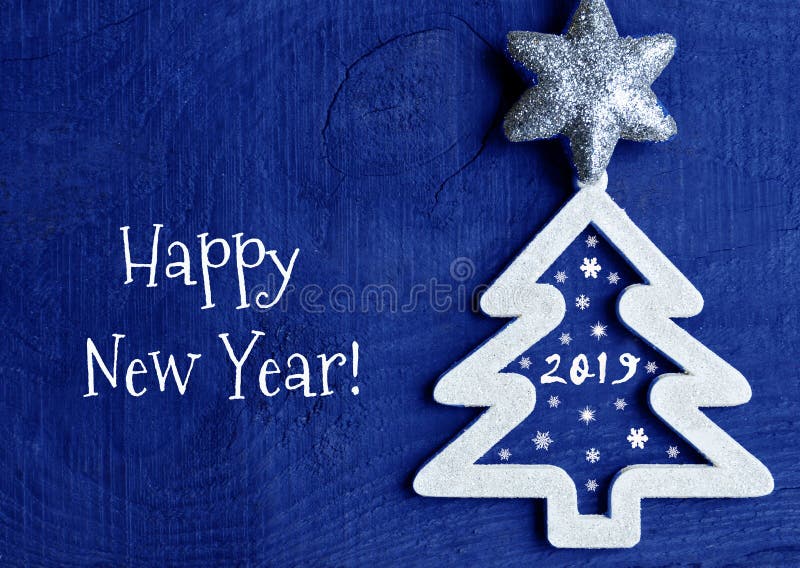 Happy New Year greeting card.White christmas tree with 2019 number on a dark blue wooden background. royalty free stock image Happy New Year greeting card.White christmas tree with 2019 number on a dark blue wooden background. royalty free stock image