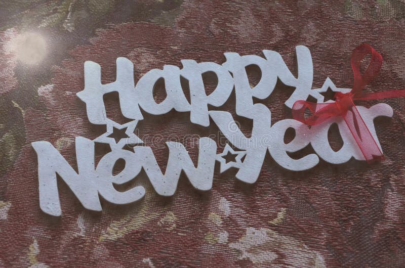 Happy New Year - white wood text in vintage style on a color background close up. Happy New Year - white wood text in vintage style on a color background close up