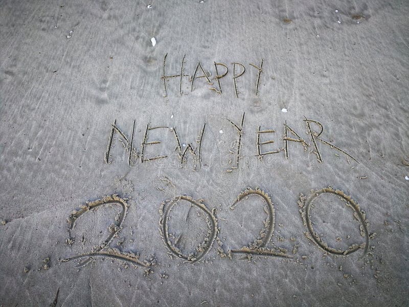 Happy new year 2020, lettering on the beach with wave and clear blue sea. Numbers 2020 year on the sea shore. stock photo