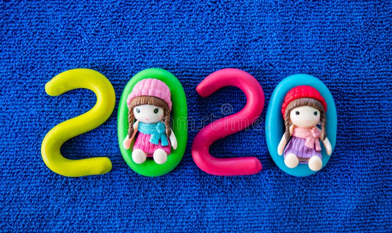 Happy New Year 2020 , molding of color clay with little girls toys on blue background. 2020, aqua, background, blue, calender, celebrate, celebration stock photos