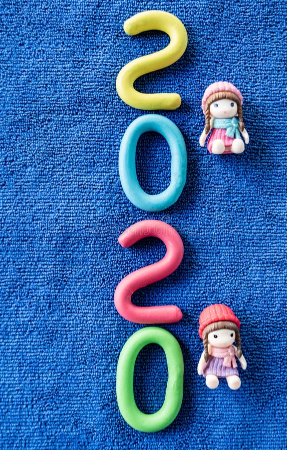 Happy New Year 2020 , molding of color clay with little girls toys on blue background. 2020, aqua, background, blue, calender, celebrate, celebration royalty free stock photography