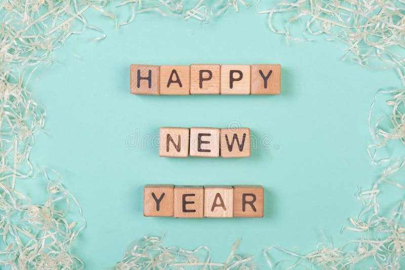 Happy new year phrase compiled with a wooden blocks with delicate curly decor. Design concept for social media and. Happy new year phrase compiled with a wooden stock photography