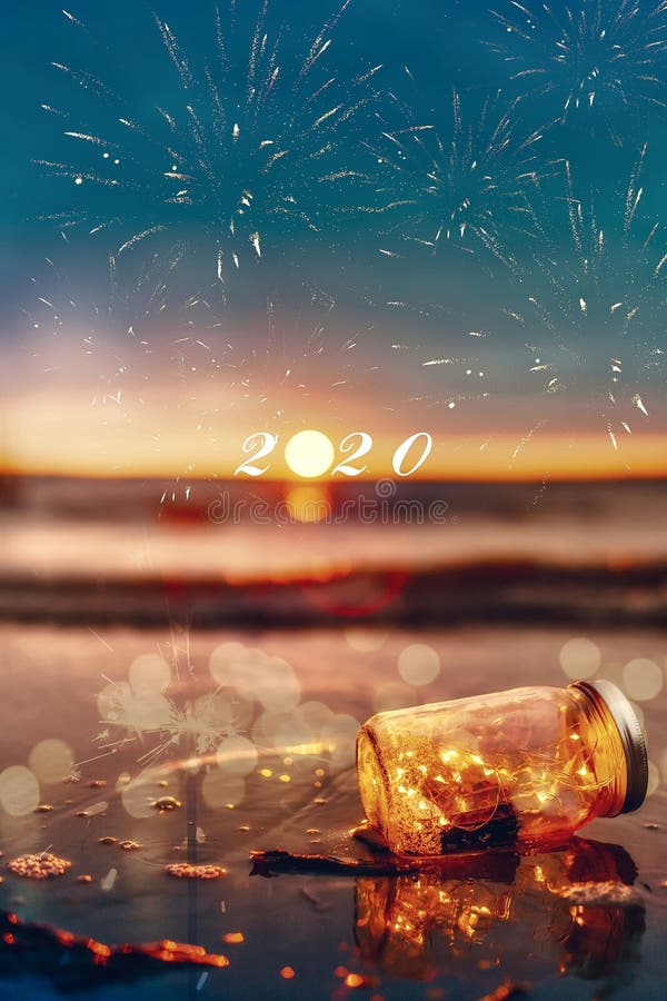 Happy new year in 2020. Sunset at the beach with fire works stock photography