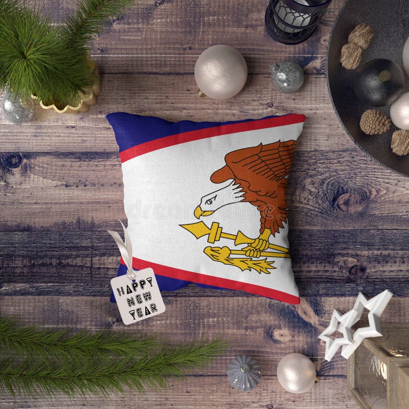 Happy New Year tag with American Samoa flag on pillow. Christmas decoration concept on wooden table with lovely objects stock photography Happy New Year tag with American Samoa flag on pillow. Christmas decoration concept on wooden table with lovely objects stock photography