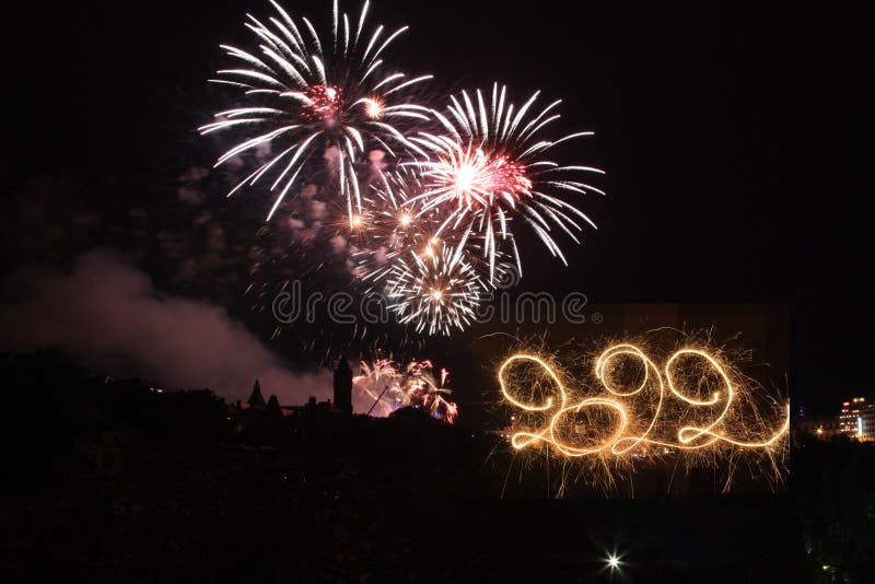 Happy New Year 2022. Written with Sparklers against Fireworks background stock photo