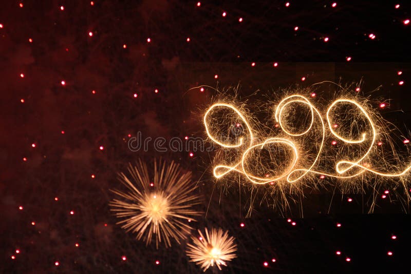 Happy New Year 2022. Written with Sparklers against Fireworks background royalty free stock photo