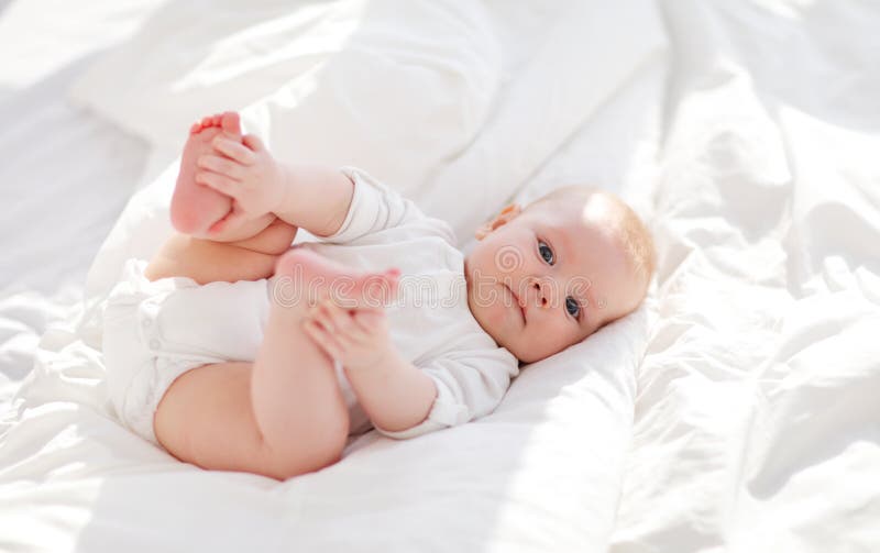 Happy newborn baby on bed