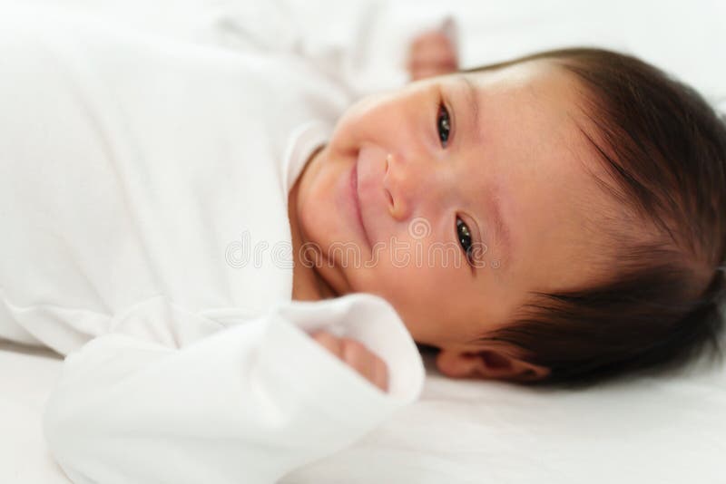 Happy Newborn Baby Smilling while Lying on a Bed Stock Photo Image of