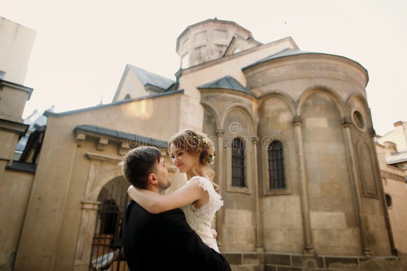 Happy newlyweds portait - strong handsome groom lifting bride in royalty free stock image Happy newlyweds portait - strong handsome groom lifting bride in royalty free stock image