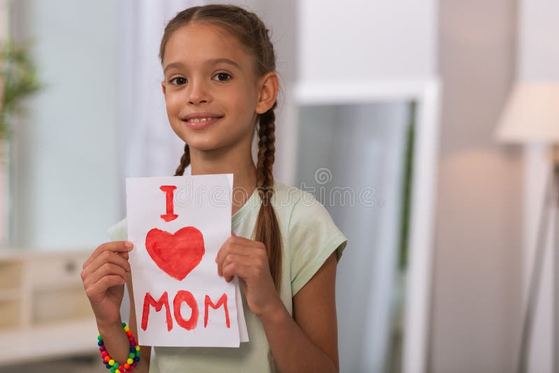 Happy nice girl holding a painting at home