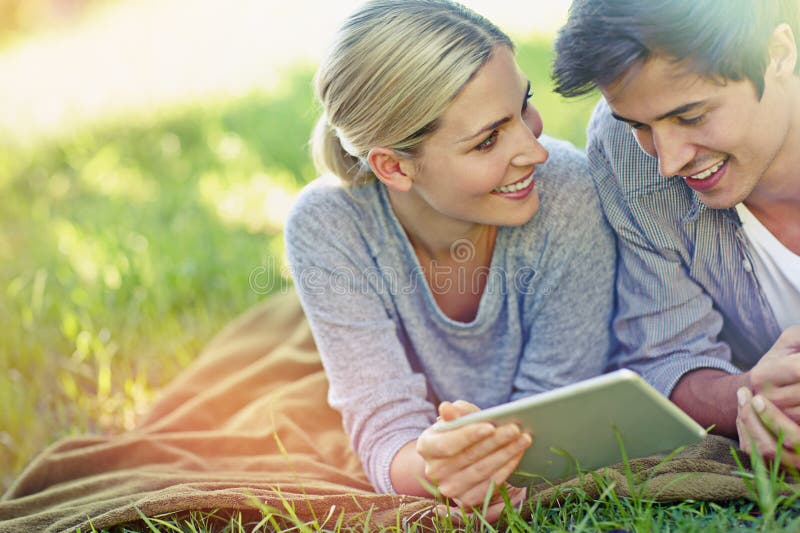 Happy park и пара на планшете на пикнике для онлайн чата социальных сетей и bonding в выходные. расслабиться на свиданиях стоковые изображения