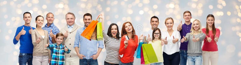 Happy people with shopping bags showing thumbs up