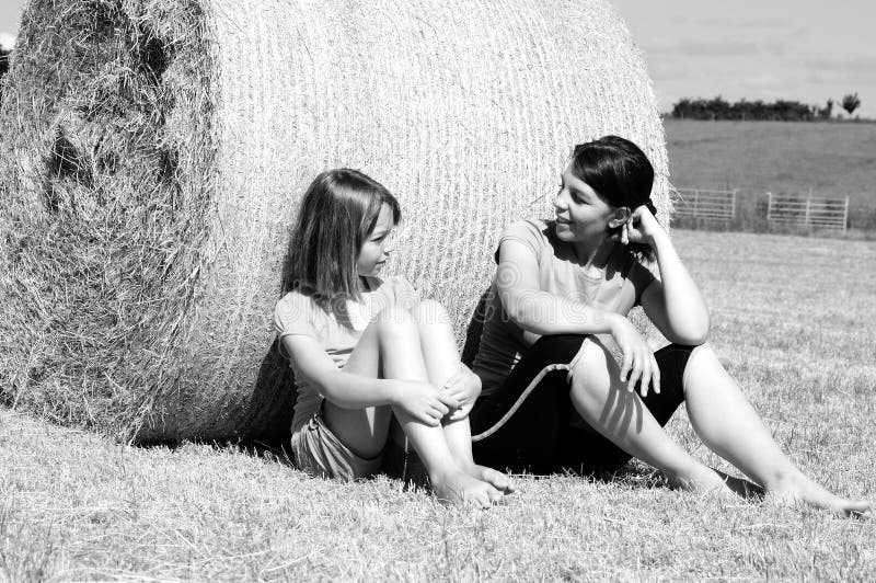 Happy people talking in nature on hay bales