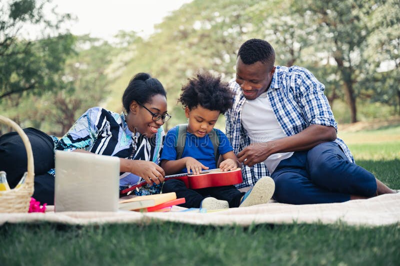 Happy picnic relax black people family with son in garden. Holiday happy picnic relax black people family with son in garden