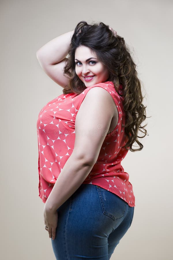 Foto de Happy plus size model in casual clothes, fat woman on gray