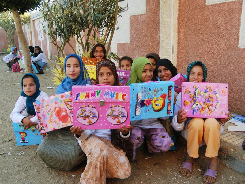 Happy poor muslim girls in veil received presents and gifts in Egypt