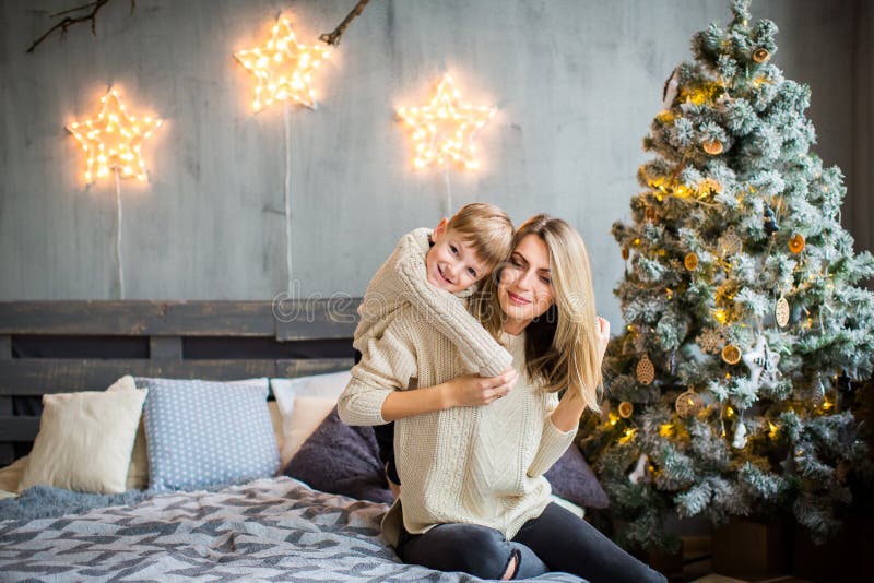 Happy portrait of mother and son playing on New Year`s background.