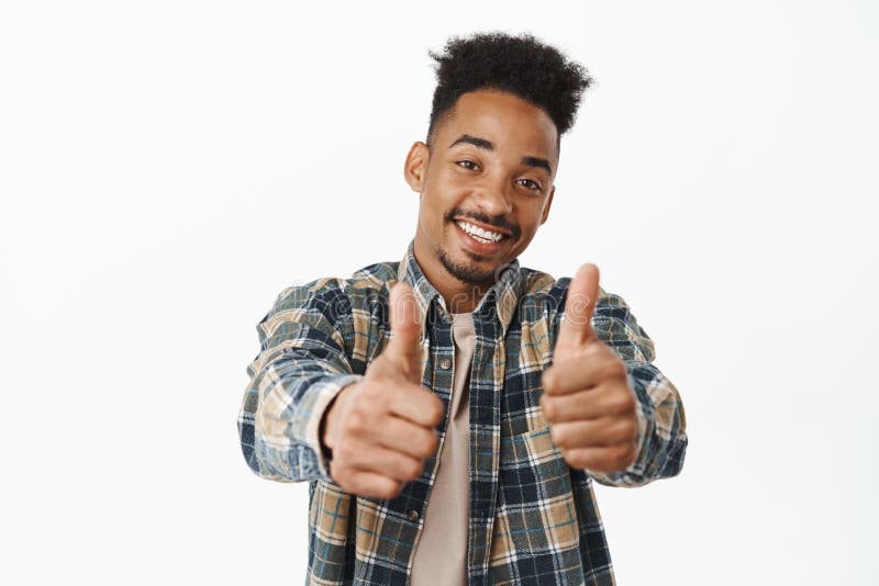 Happy and positive african american man showing thumbs up, smiling satisfied, praise excellent great job, say yes