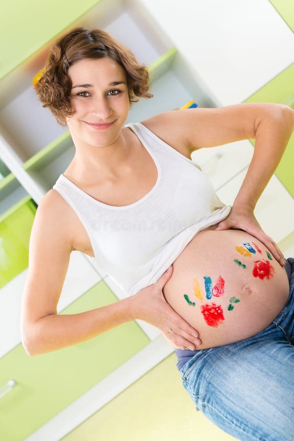 Happy pregnant girl with palm stamps on belly