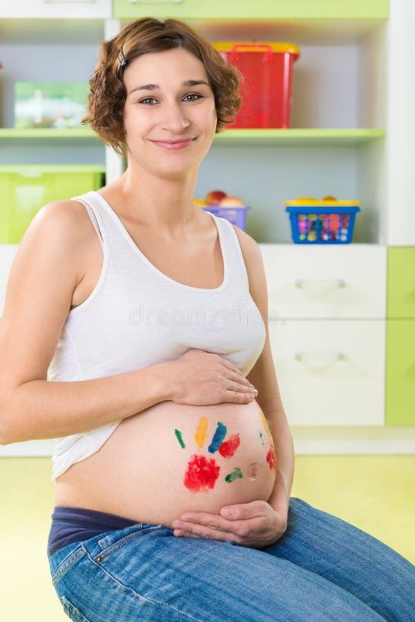 Happy pregnant girl with palm stamps on belly