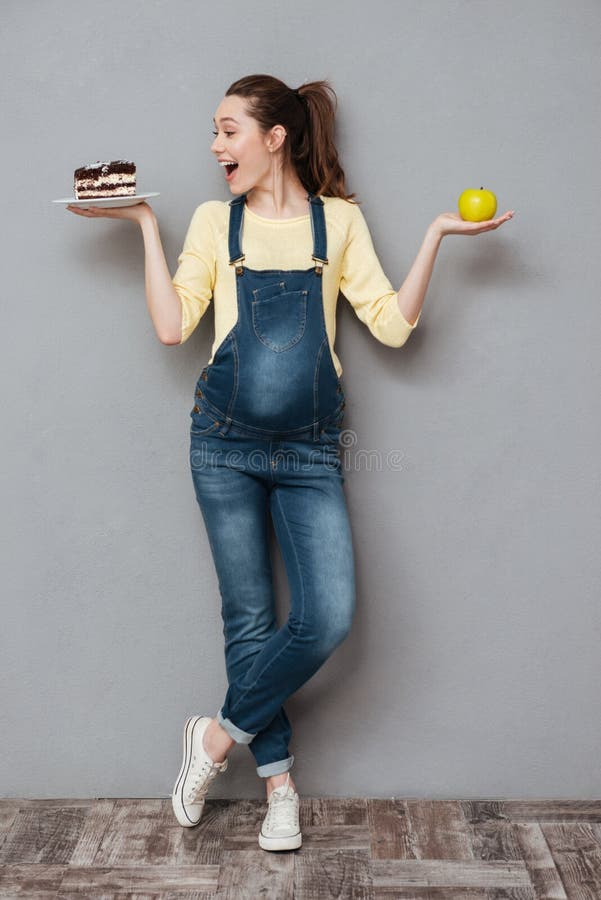 Happy pregnant lady holding sweet cake and apple. stock images Happy pregnant lady holding sweet cake and apple. stock images