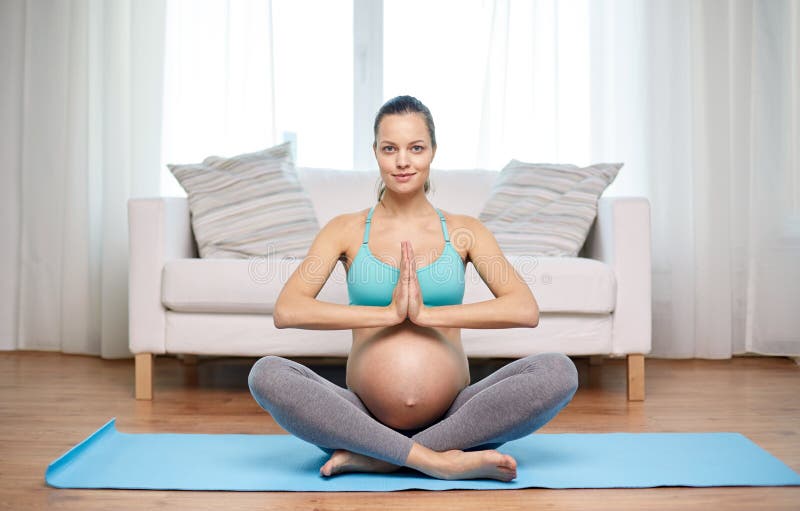 Happy pregnant woman meditating at home