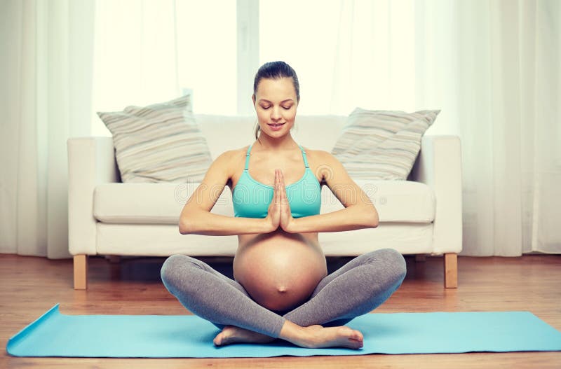 Happy pregnant woman meditating at home