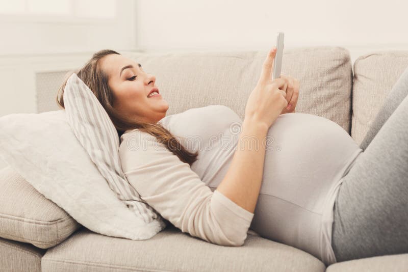 Happy pregnant woman using smartphone
