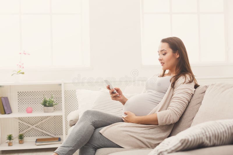 Happy pregnant woman using smartphone