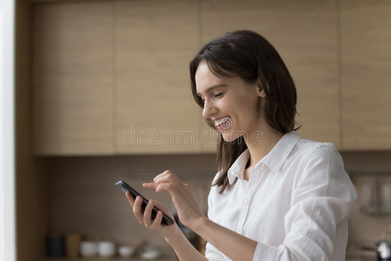 Happy pretty young cellphone user woman using online application royalty free stock images