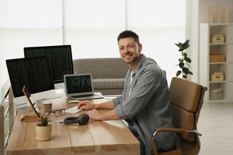 Happy programmer working at desk in office royalty free stock images