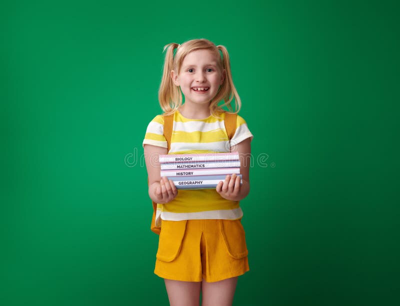 Happy pupil with backpack isolated on green with schoolbooks stock image Happy pupil with backpack isolated on green with schoolbooks stock image