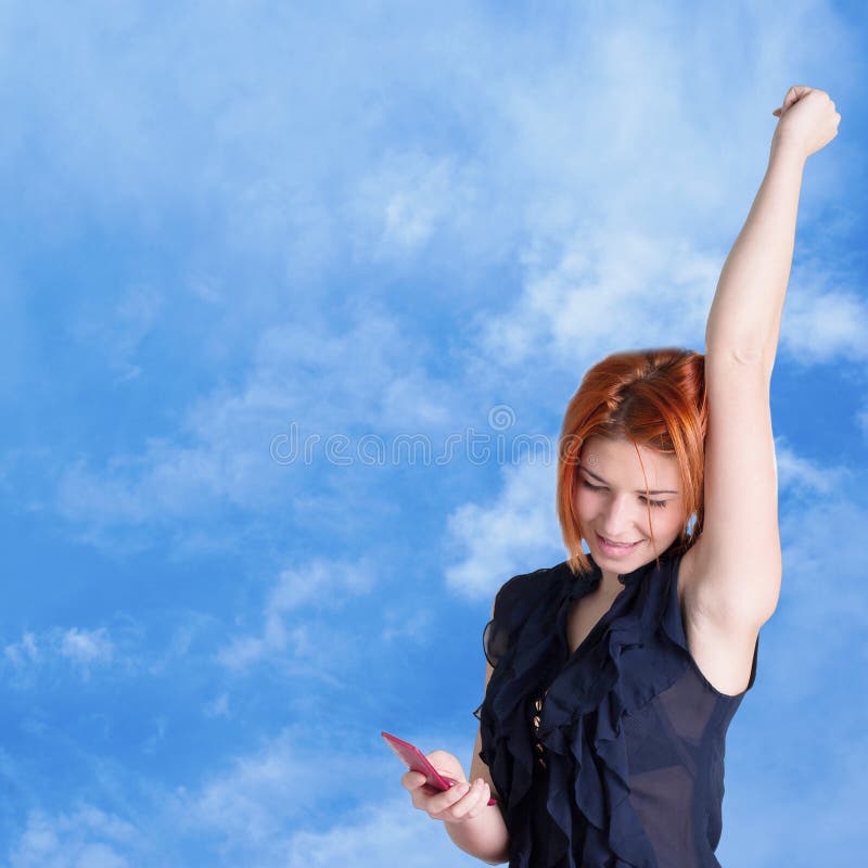 Happy red-haired girl with mobile phone stock photo
