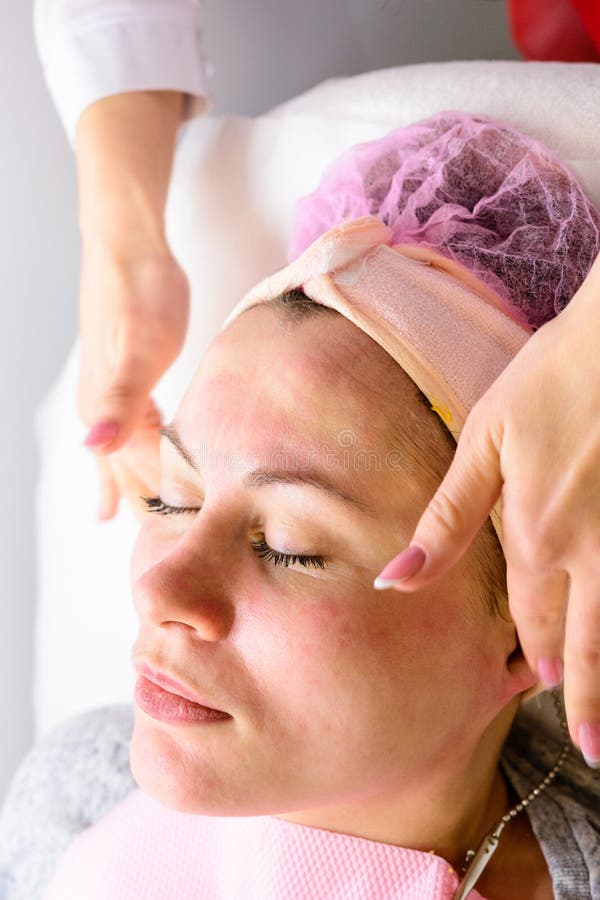 Happy And Relaxed Woman On Cosmetology Procedures Massage And Applying Face Cream Stock Image