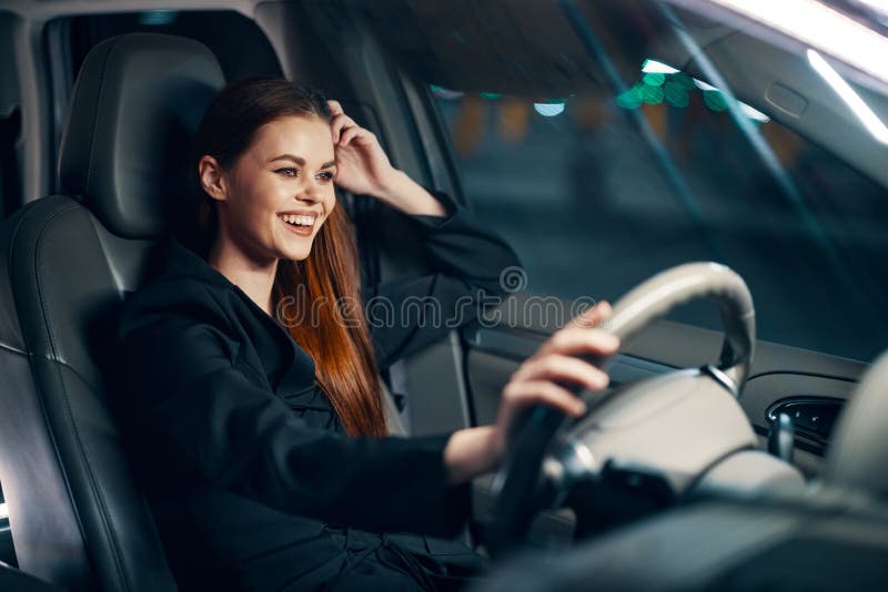 A Happy Relaxed Woman Enjoys A Night Drive While Sitting In A Car And