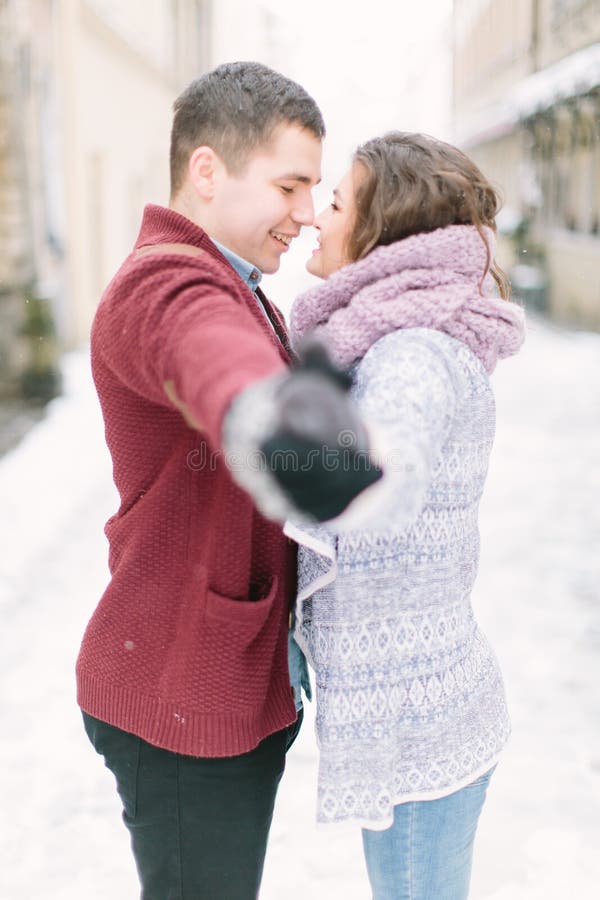 Happy and romantic caucasian couple in warm sweaters walking in winter city Lviv. Holidays, christmas, winter, love, hot royalty free stock photo Happy and romantic caucasian couple in warm sweaters walking in winter city Lviv. Holidays, christmas, winter, love, hot royalty free stock photo