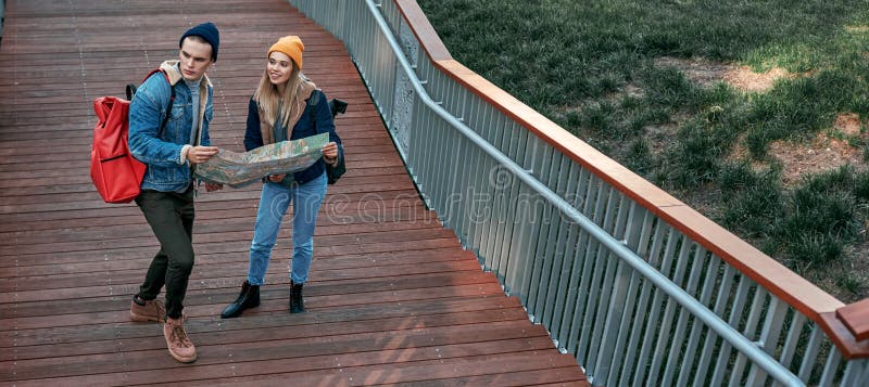 Happy romantic couple of tourists are looking for right way on steps