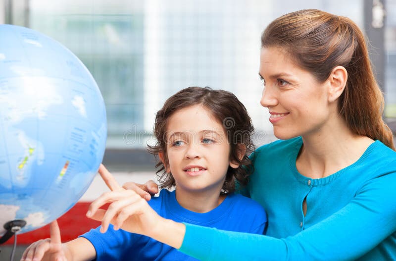Happy school concept. Female teacher explaining geography to kid royalty free stock photo Happy school concept. Female teacher explaining geography to kid royalty free stock photo