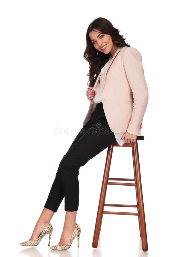 Happy seated modern business woman pulls her collar and smiles