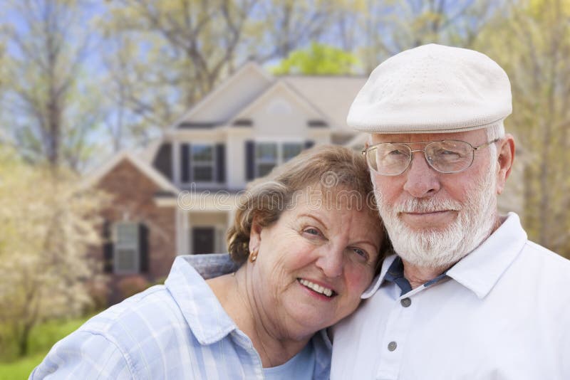 Attractive Happy Senior Couple in Front Yard of House. Attractive Happy Senior Couple in Front Yard of House.